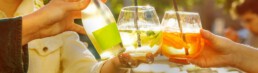 Menschen stoßen mit Getränken an