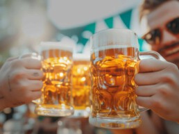 Menschen stoßen mit Bierkrügen an